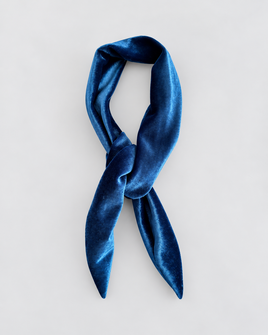 A dark blue velvet scarf tied in a knot, displayed against a light gray background.