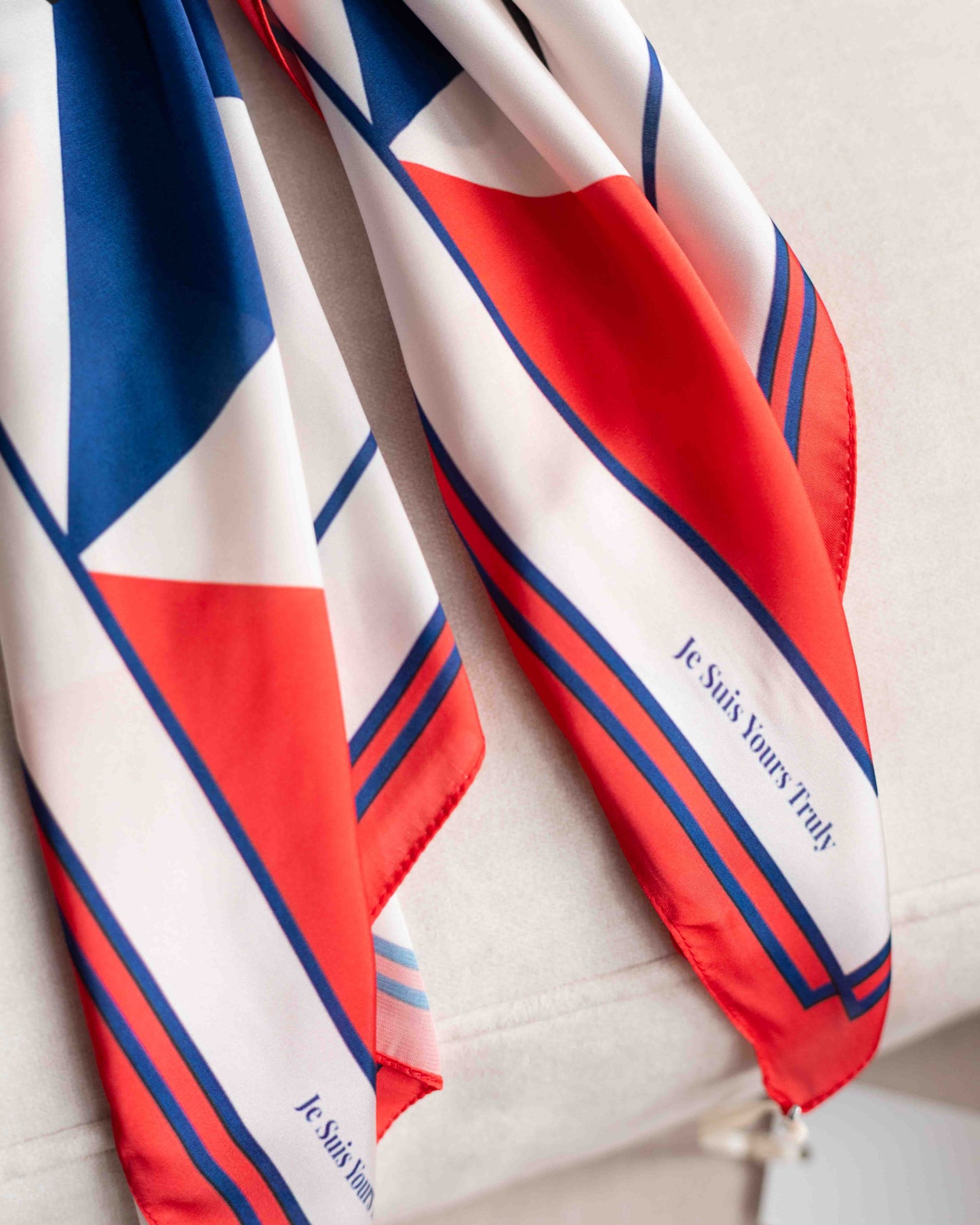 Red, white, and blue patterned scarf with text on a light background