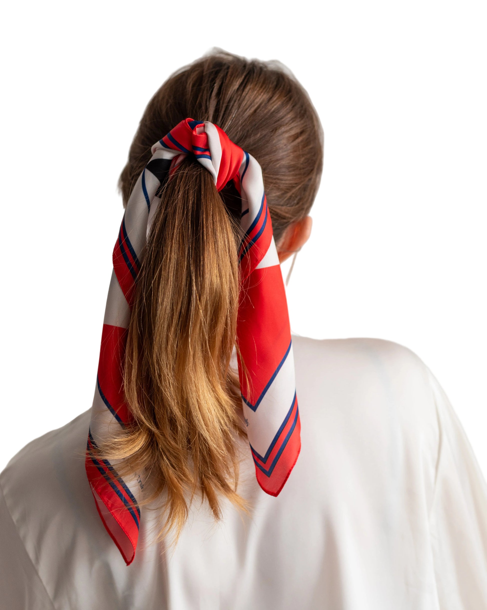 Person with a red, white, and blue striped hair scarf tied around their ponytail against a plain background