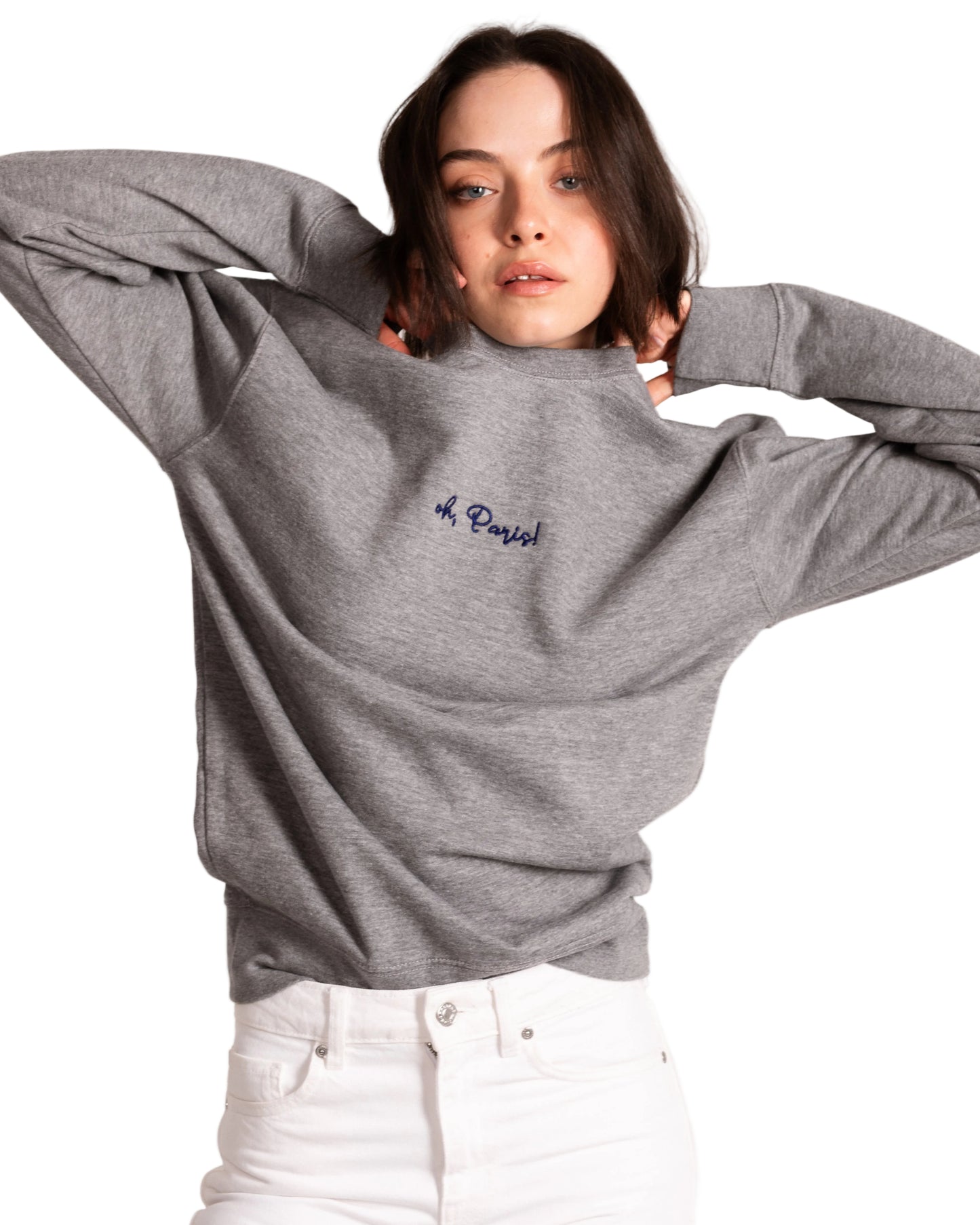 Person wearing a gray sweatshirt with 'oh paris' text on a white background