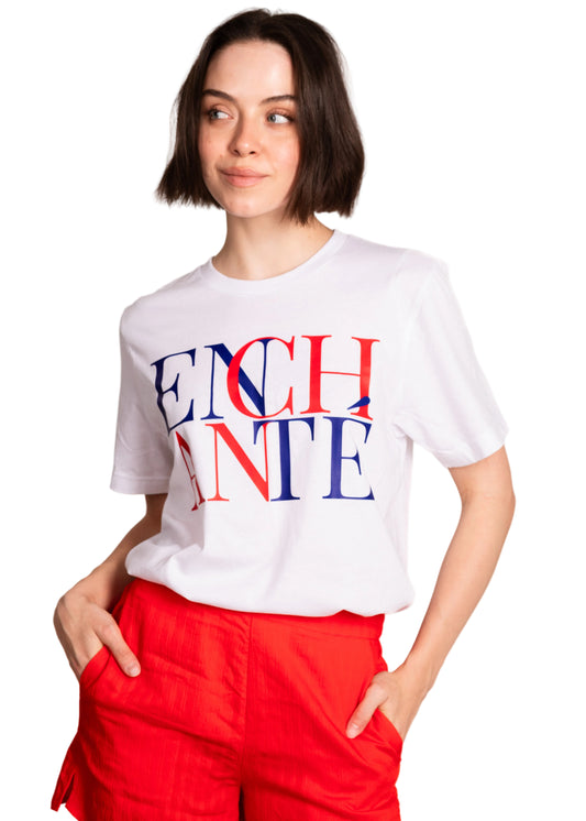 Person wearing a white t-shirt with colorful text on a plain background