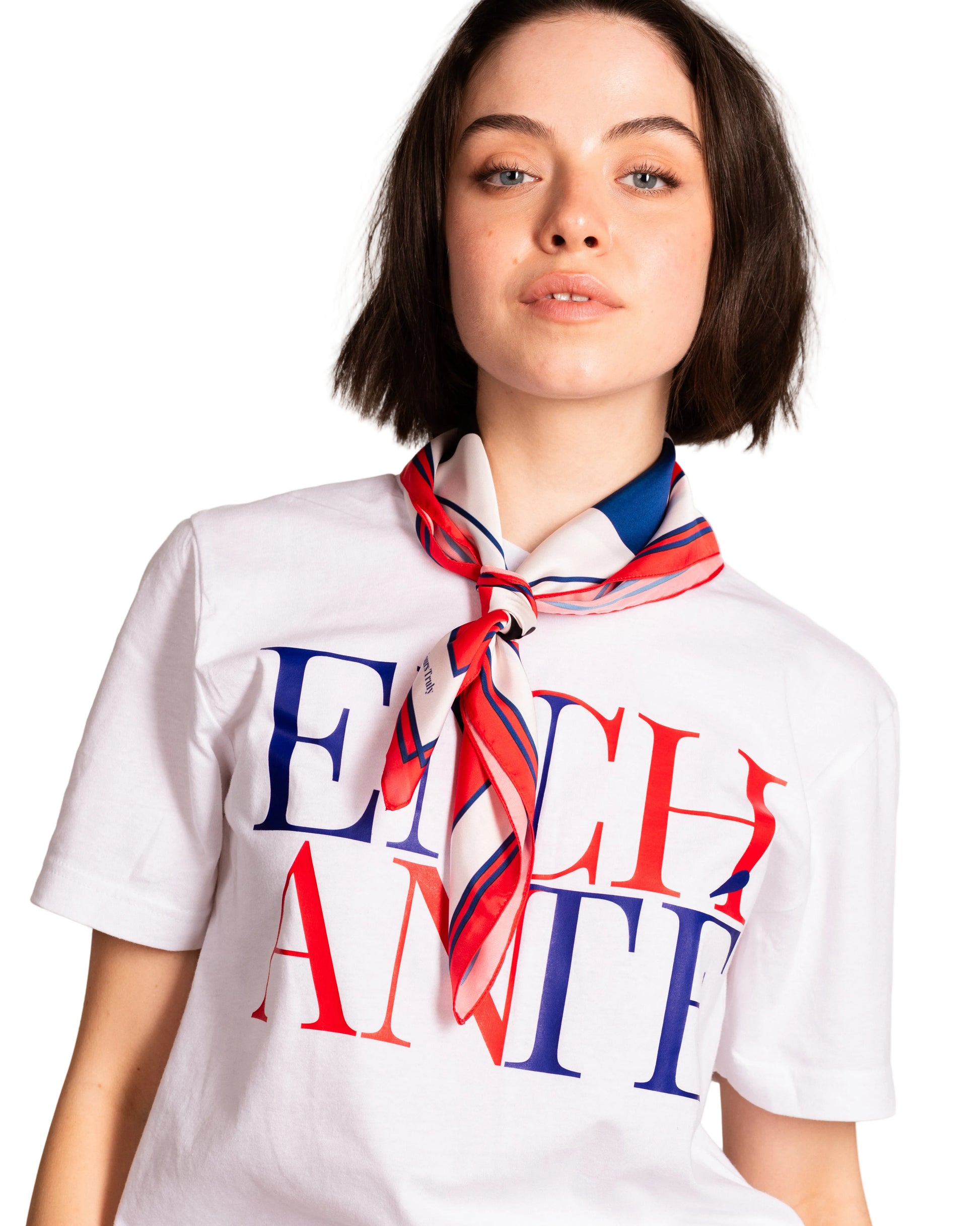 Person wearing a white t-shirt with colorful text and a scarf