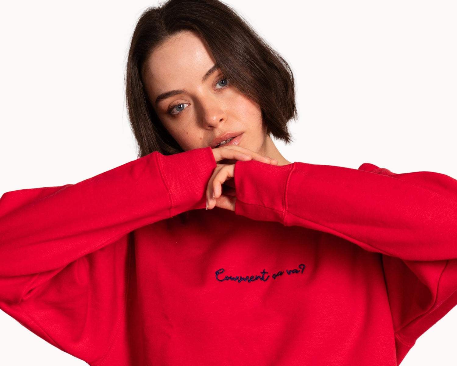 Person wearing a red sweatshirt with text on a plain background