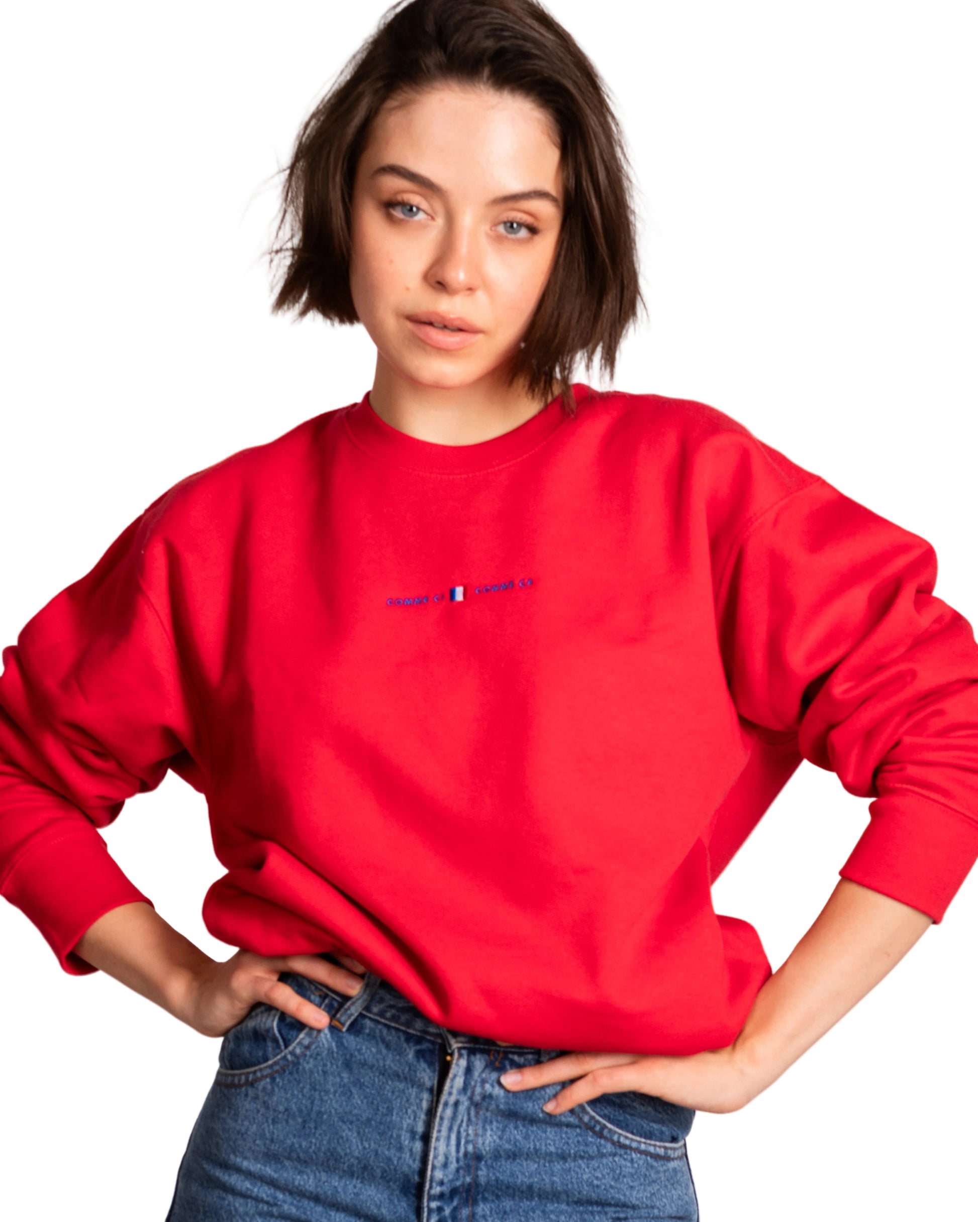 Person wearing a red sweatshirt with a logo on a plain background