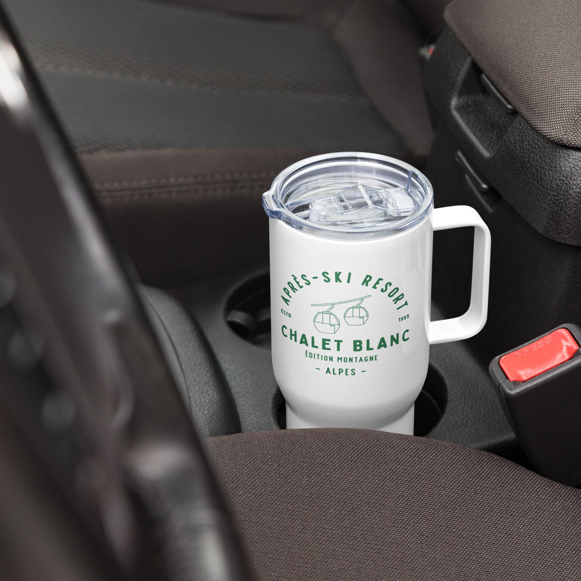 White mug with green text and graphics in a car cup holder